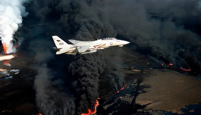 Un avión F-14A de los Estados Unidos sobrevuela un pozo de petróleo incendiado